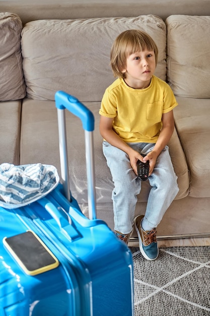 A sad child watches bad news the family cannot leave because of the closed borders family relocation