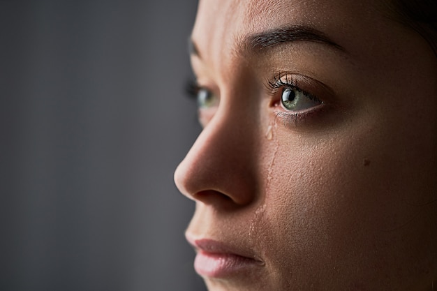 Sad desperate crying woman with tears eyes during trouble