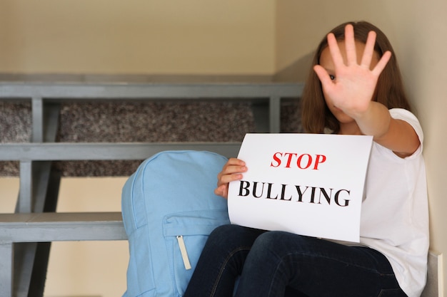 Sad girl holding a stop bullying sign