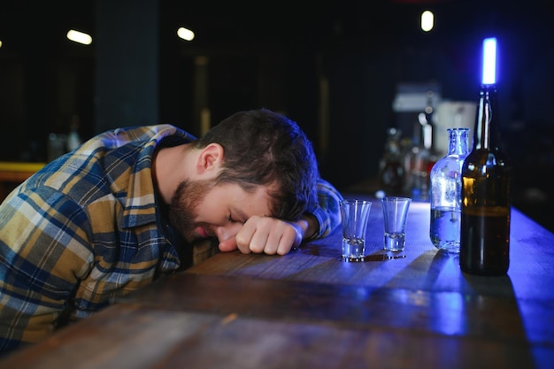 Sad man sitting at bar counter alcohol addiction