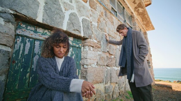 Photo sad man woman contemplating at beachside zoom out upset two people at castle