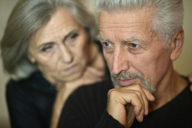 Sad Mature couple near wall in the room