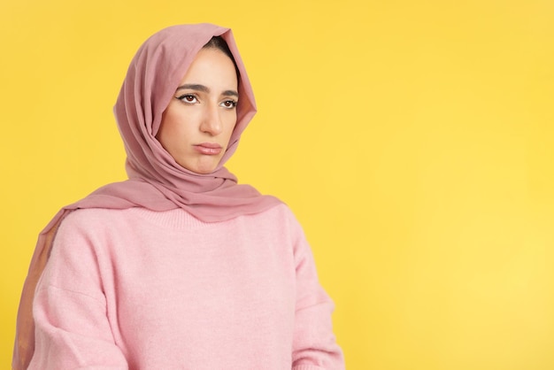 Sad muslim woman wearing head scarf looking away