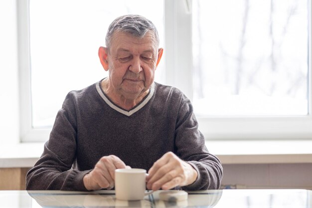 Sad portrait of elderly man the senior sits at