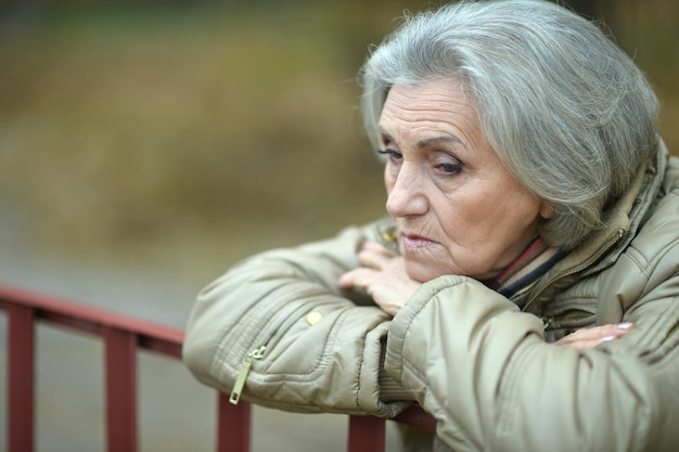 Sad senior woman in park