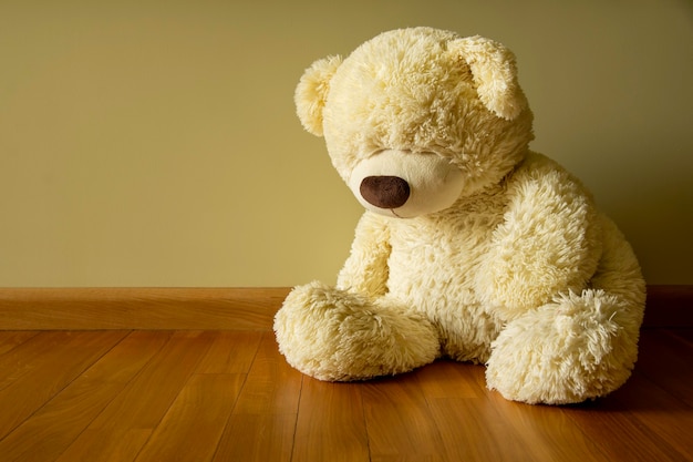 Sad Teddy bear sitting alone on the floor Loneliness and Child abuse concept