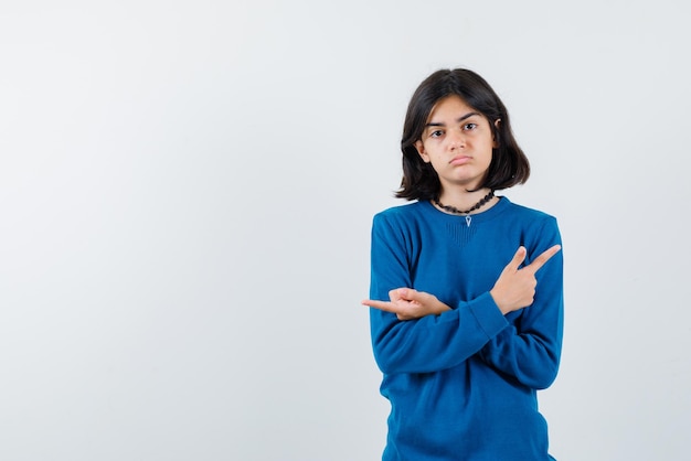 The sad teenage girl is showing sideways with forefingers on white background