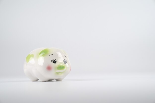 Sad White green and pink piggy back in front of white background.