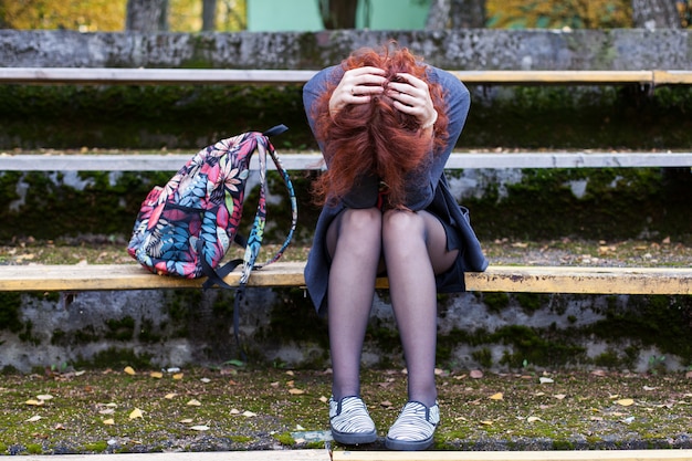 Sad woman sitting on the bench in the park