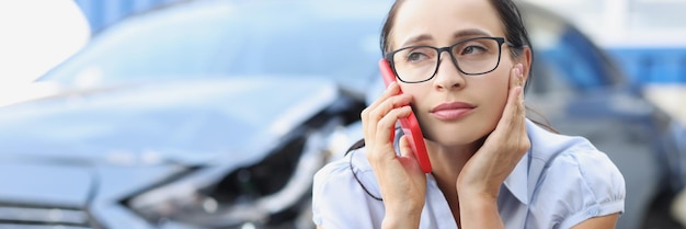 Sad woman talking on phone after broken car reporting an accident concept