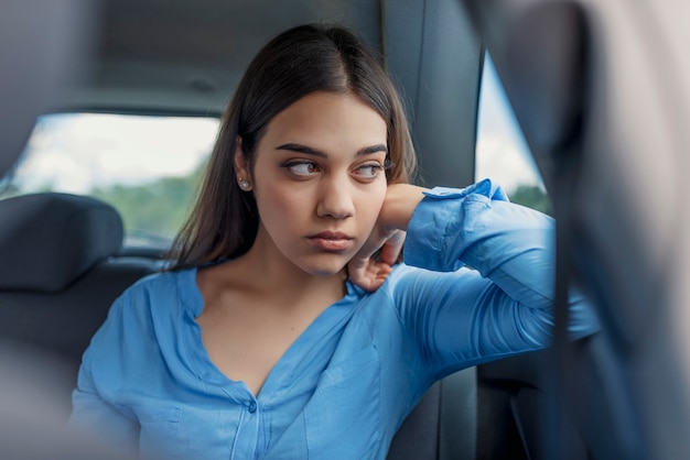 Sad woman or teenager girl looking through a car window