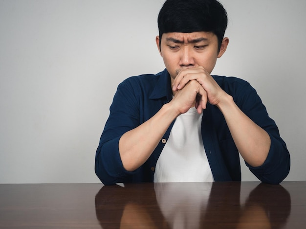 Sadness asian man sit at table depressed emotion