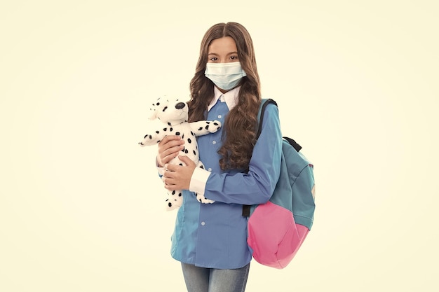 Safe to learn during COVID19 Kid wear mask holding toy Safe return to school Student safety