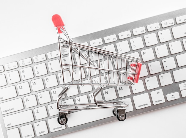 Safe Online shopping concept. Shopping cart protected with hand on white