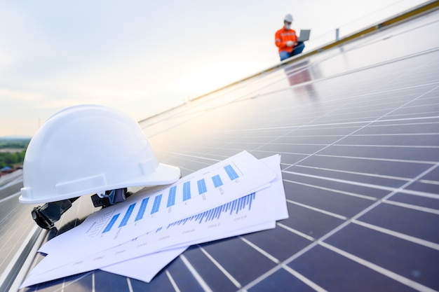 Safety Engineer Helmet In industrial premises where solar panels are installed using solar energy First concept solar power station background.