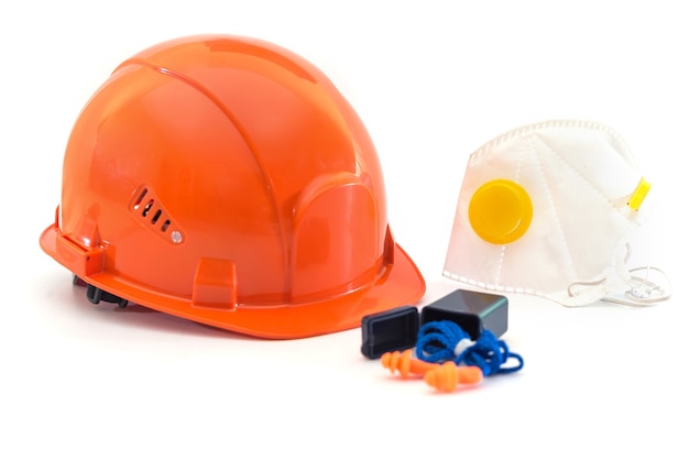 Safety equipment with helmet, respirator, ear plugs and gloves isolated on white. Means of protection for a large industrial enterprise.