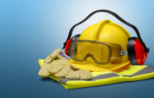 Safety helmet with gloves and glasses on light background