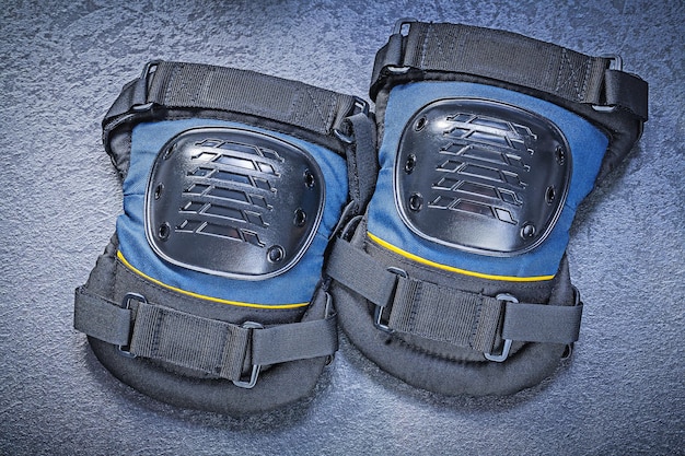 Safety knee protectors on black background construction concept