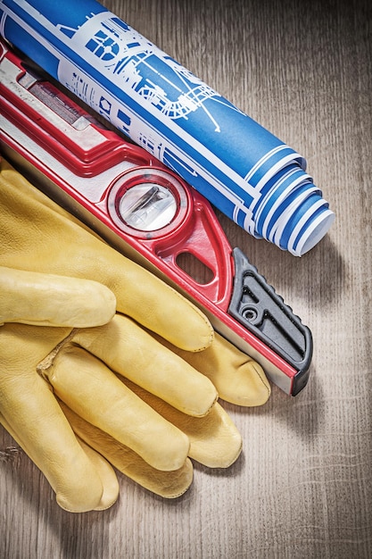 Safety leather gloves construction level drawings on wood board