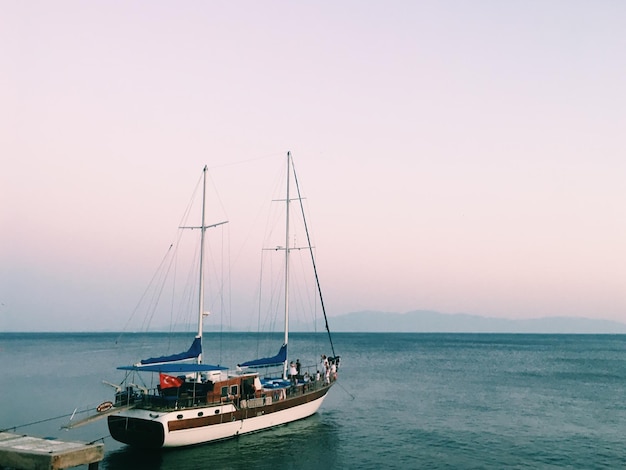 Sailboat sailing on sea against clear sky