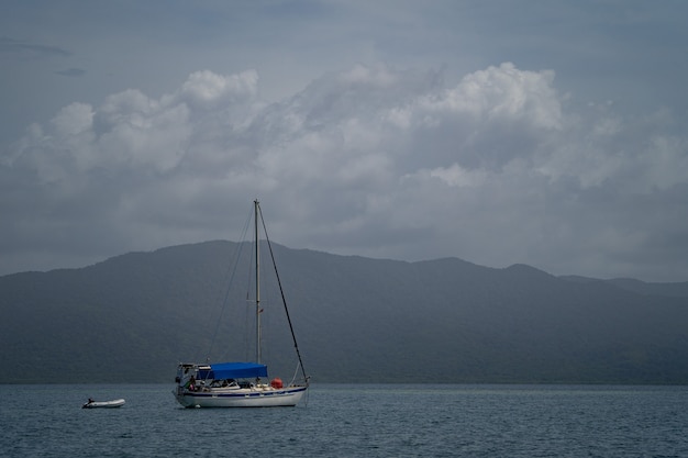 Sailboat in the sea in the evening sunlight over beautiful big mountains background. Adventure, active vacation concept . High quality photo