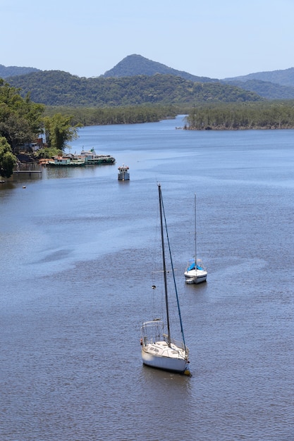 Sailboats anchored in calm blue waters at the river mouth