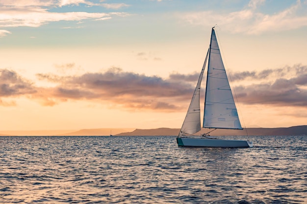 Sailboats on the background of the sunset over the sea