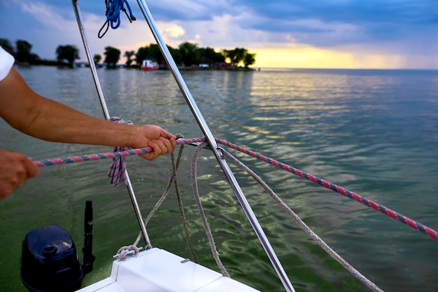 Sailor hand pull on rope aboard the ship on picturesque seascape. shallow depth of field photo.