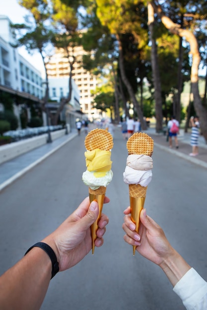 Saint Stephen Montenegro 07072021 Beautiful bright ice cream with different flavors in the hands of a young couple in love Beautiful city streets Leisure concept