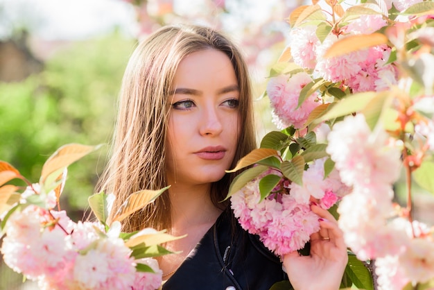 Sakura tree blooming. Soft and tender. Gorgeous flower and female beauty. Pink paradise. Woman in spring flower bloom. Skincare and spa. Natural cosmetics for skin. Girl in cherry blossom flower.