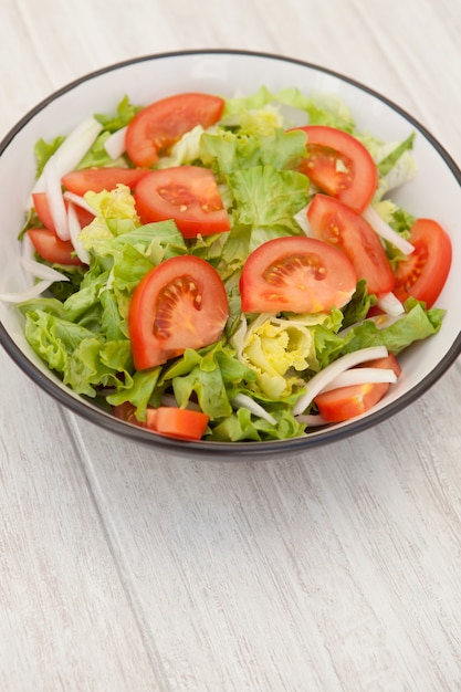 Salad bowl on a white wooden background