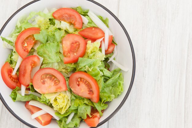 Salad bowl on a white wooden background