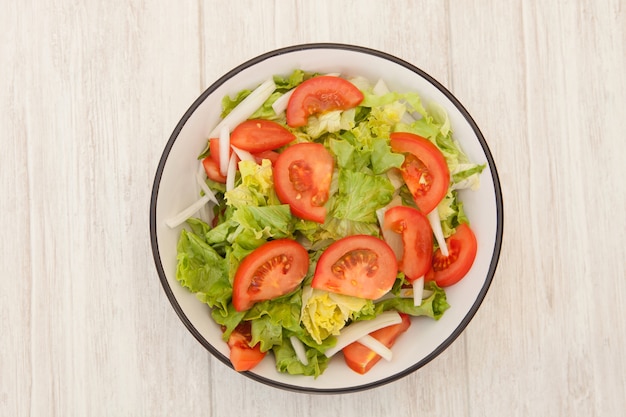 Salad bowl on a white wooden background