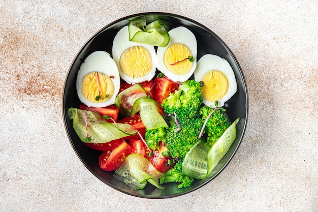 Salad buddha bowl boiled egg broccoli tomato cucumber vegetables meal snack on the table