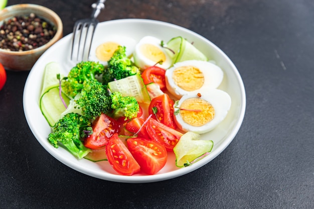 Salad buddha bowl boiled egg broccoli tomato cucumber vegetables meal snack on the table