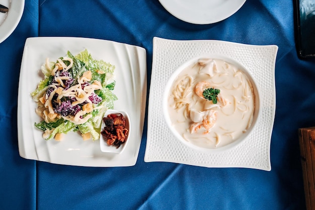 Salad cesar and sea food spaghetti flat lay Top view table of Italian food