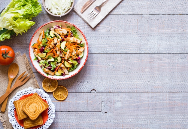 Salad of chicken breast with zucchini and cherry tomatoes, on a wooden background