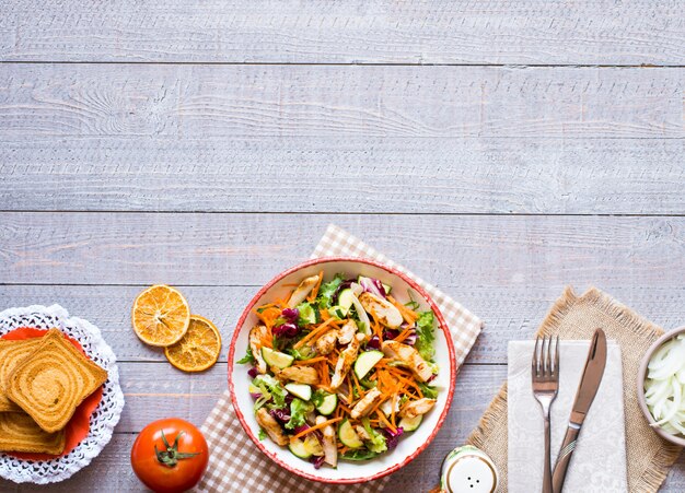 Salad of chicken breast with zucchini and cherry tomatoes, on a wooden background