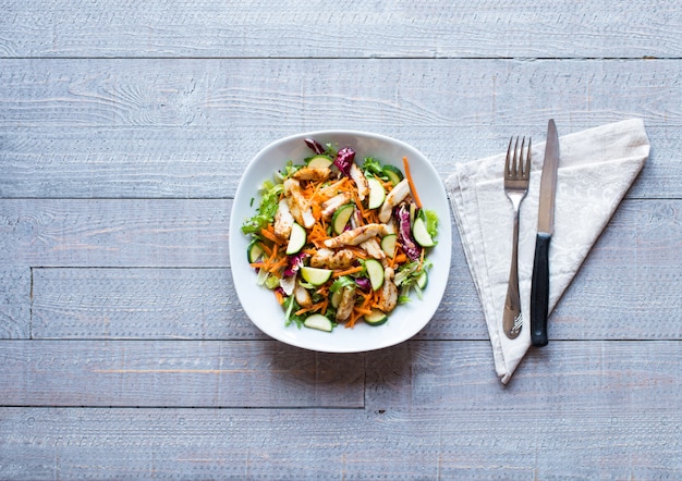 Salad of chicken breast with zucchini and cherry tomatoes, on a wooden background