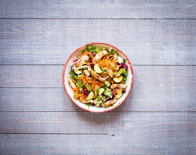 Salad of chicken breast with zucchini and cherry tomatoes, on a wooden surface