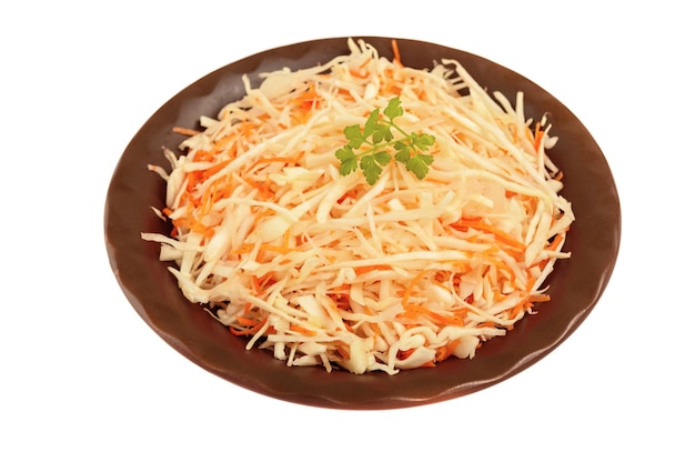 Salad of fresh cabbage and carrots in a clay bowl on a white background is insulated