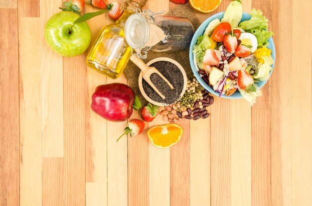 Salad fresh vegetables and fruit on wooden table