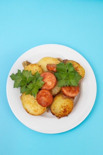 Salad fried potato and smoked sausages on plate