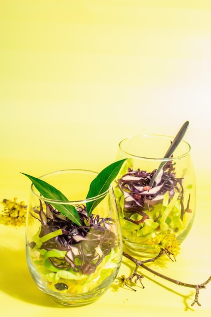 Salad from mixed cabbage served in glasses Fresh vegan vitamin food Spices olive oil dry berries