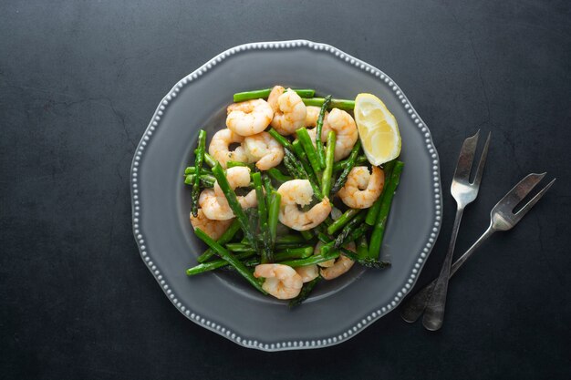 Salad from shrimp and green asparagus. Healthy seafood salad in plate. Top view.