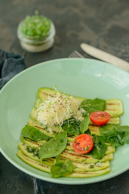 Salad from zucchini slices with cherry tomato, cream cheese and micro greens. Vegetarian food