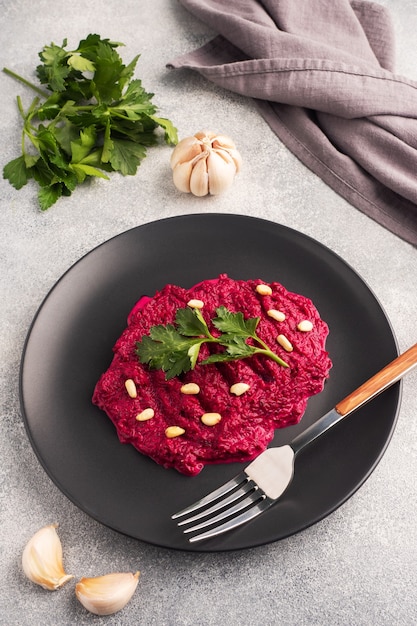 Salad of grated beetroot pine nuts and parsley with cream sauce on a plate