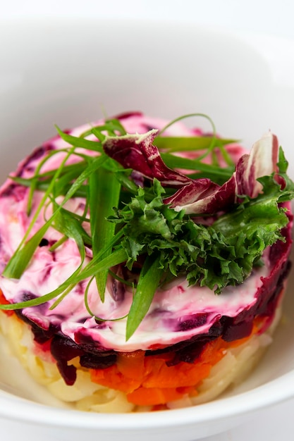 Salad herring under a fur coat with herbs Traditional Russian appetizer of beets and salted fish Closeup Vertical