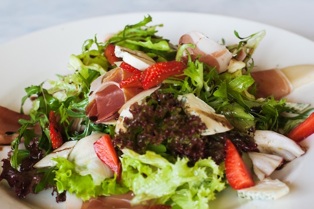 Salad lettuce with parma ham blue cheese and strawberry serving in restaurant Gourmet cuisine close up picture