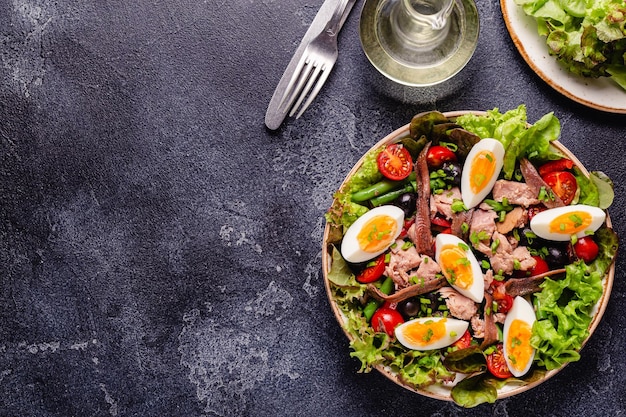 Salad Nicoise with tuna eggs green beans tomatoes olives lettuce and anchovies